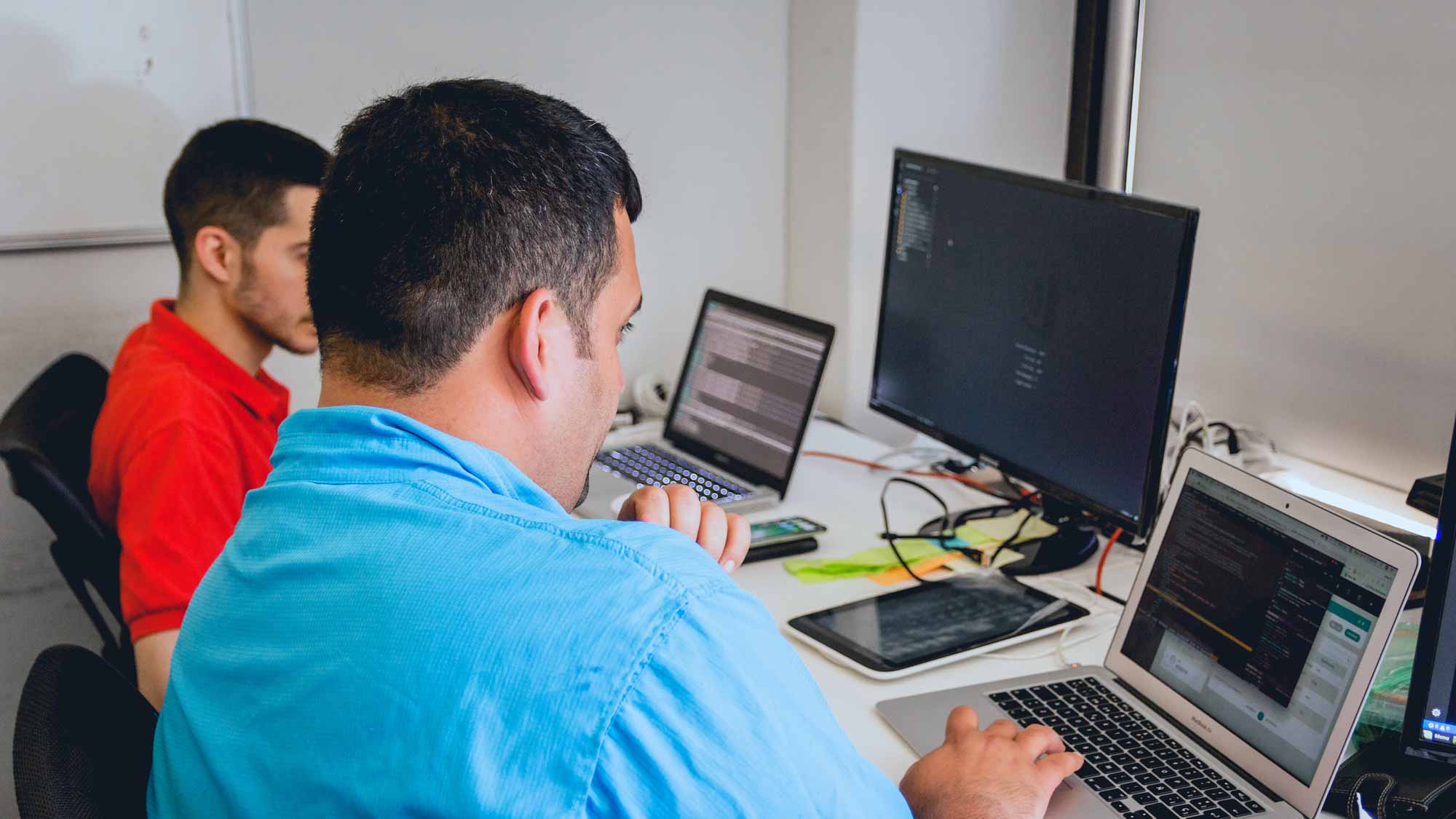 Man showing something on computer to another one