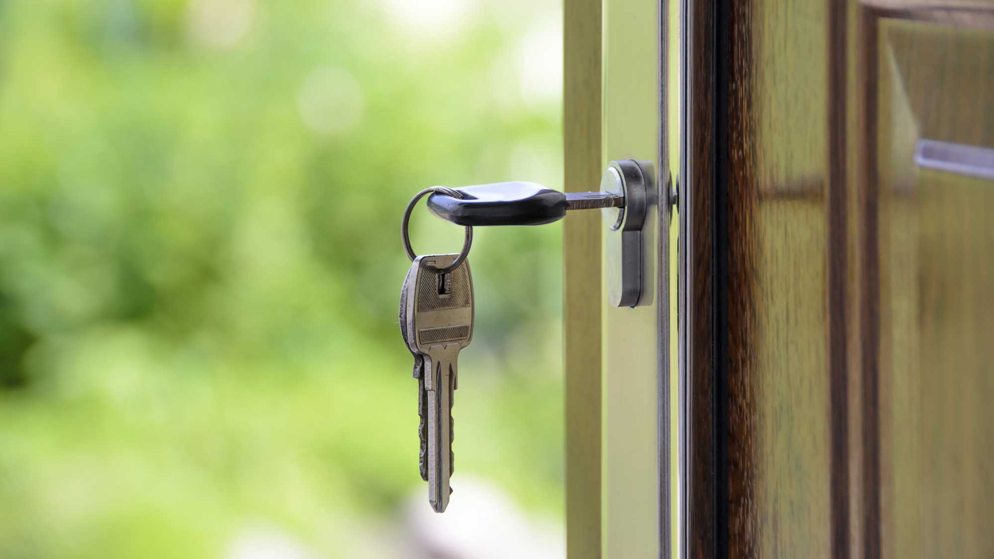 A key on an open door denoting real estate