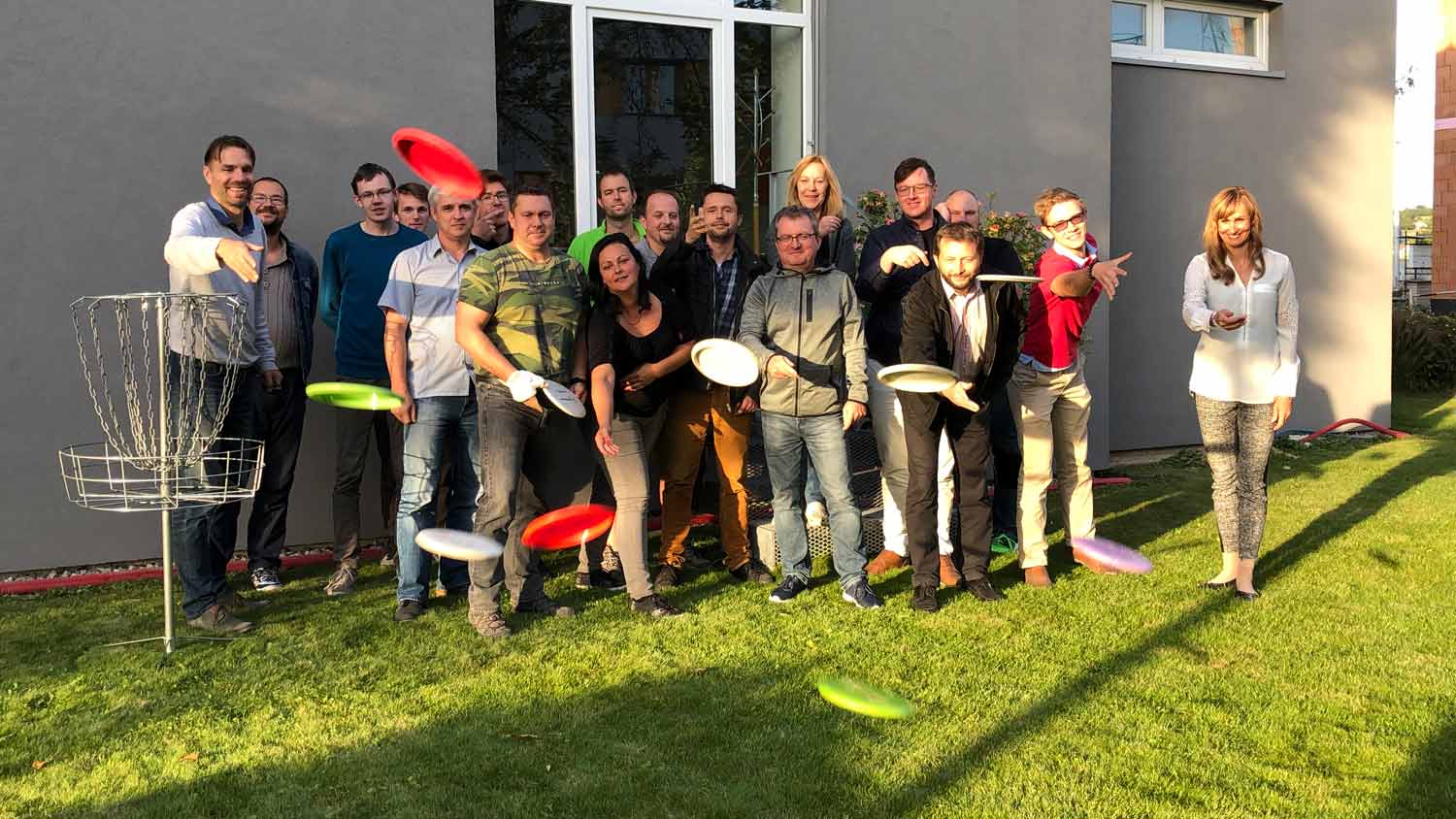 All the K-net team in front of building playing disc golf