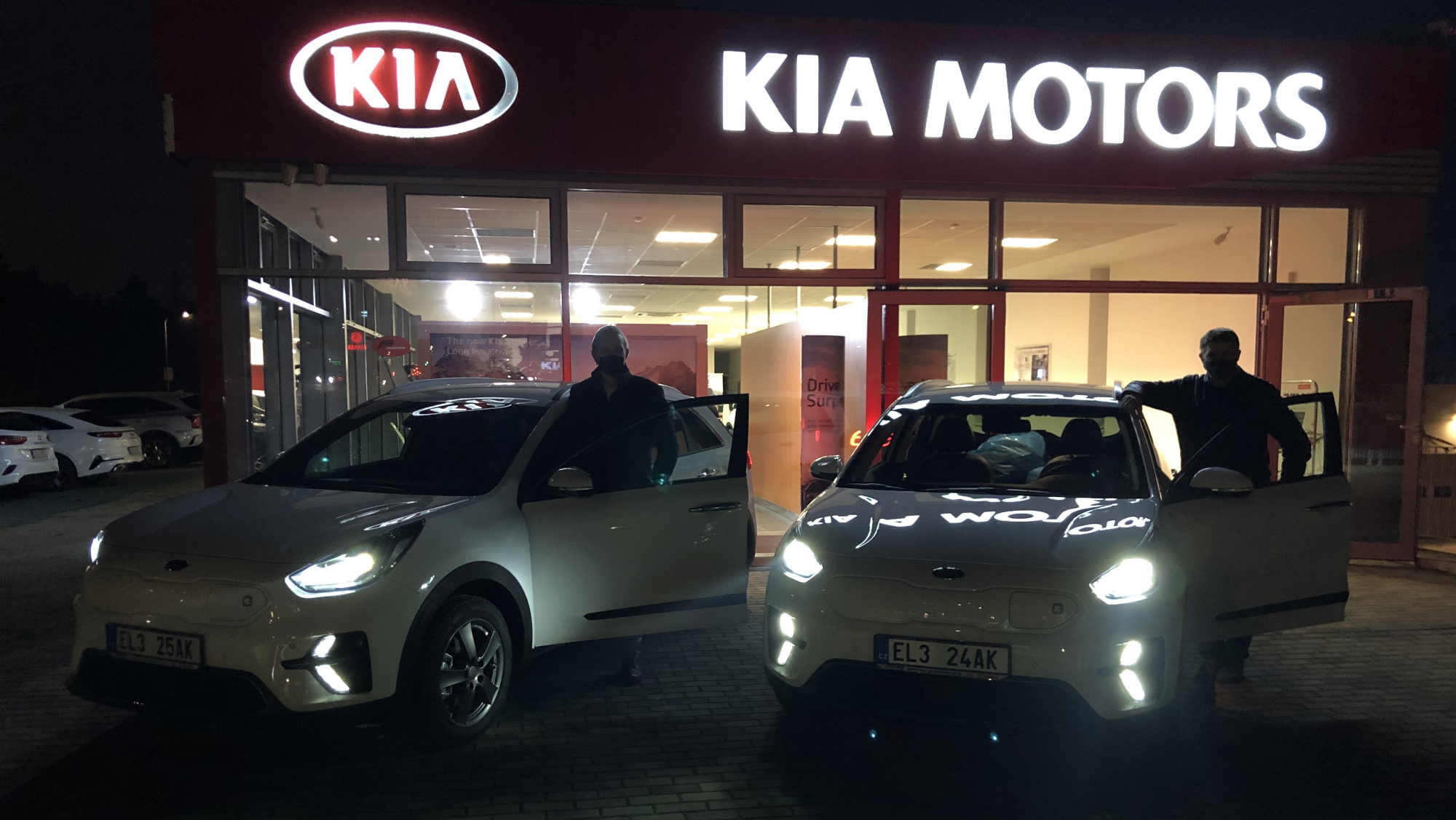 Nové elektromobily značky Kia před autosalonem