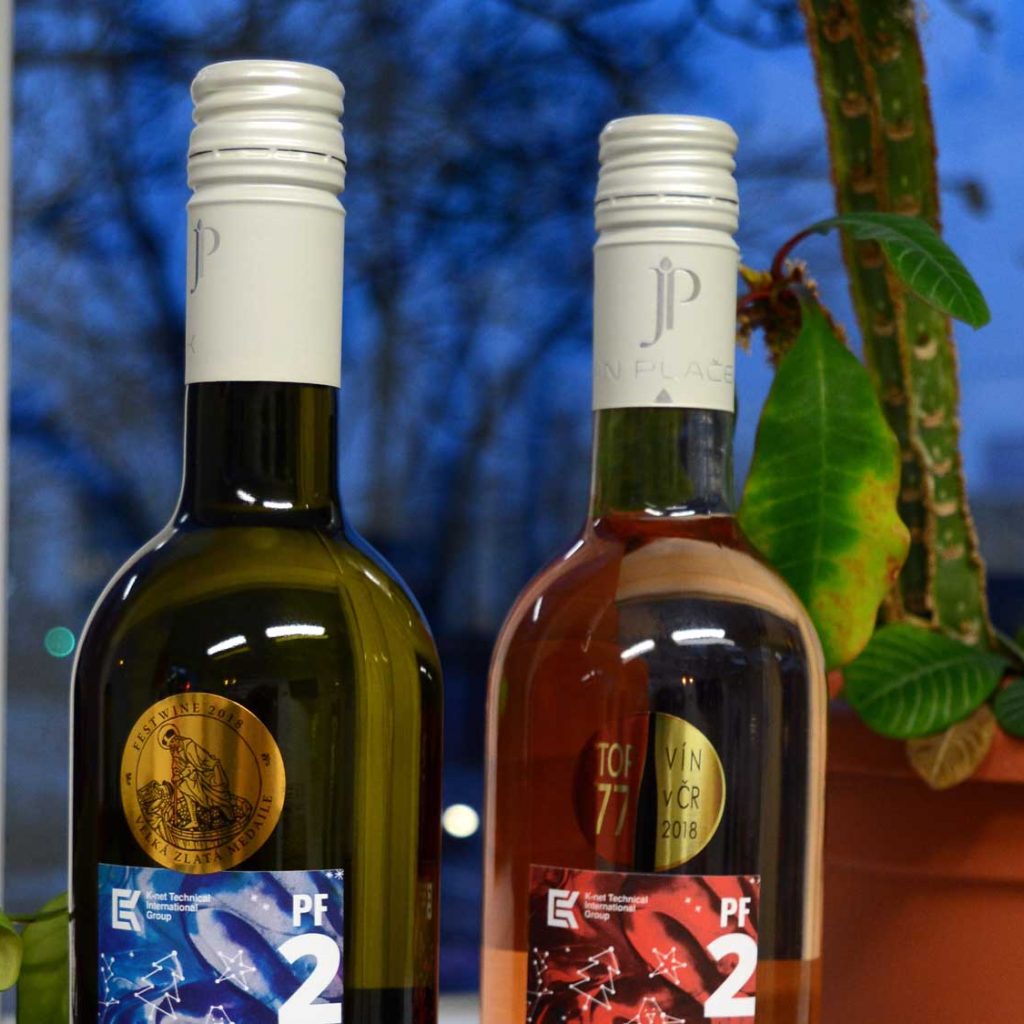 moravsky-vinarsky-podzim-2018-k-net Bottles of red wine and rosé with the K-net logo in front of window